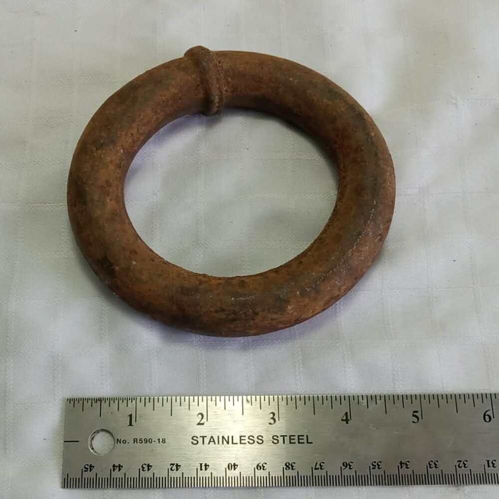 Vintage ring made of rusted iron metal that could be a mooring ring.
